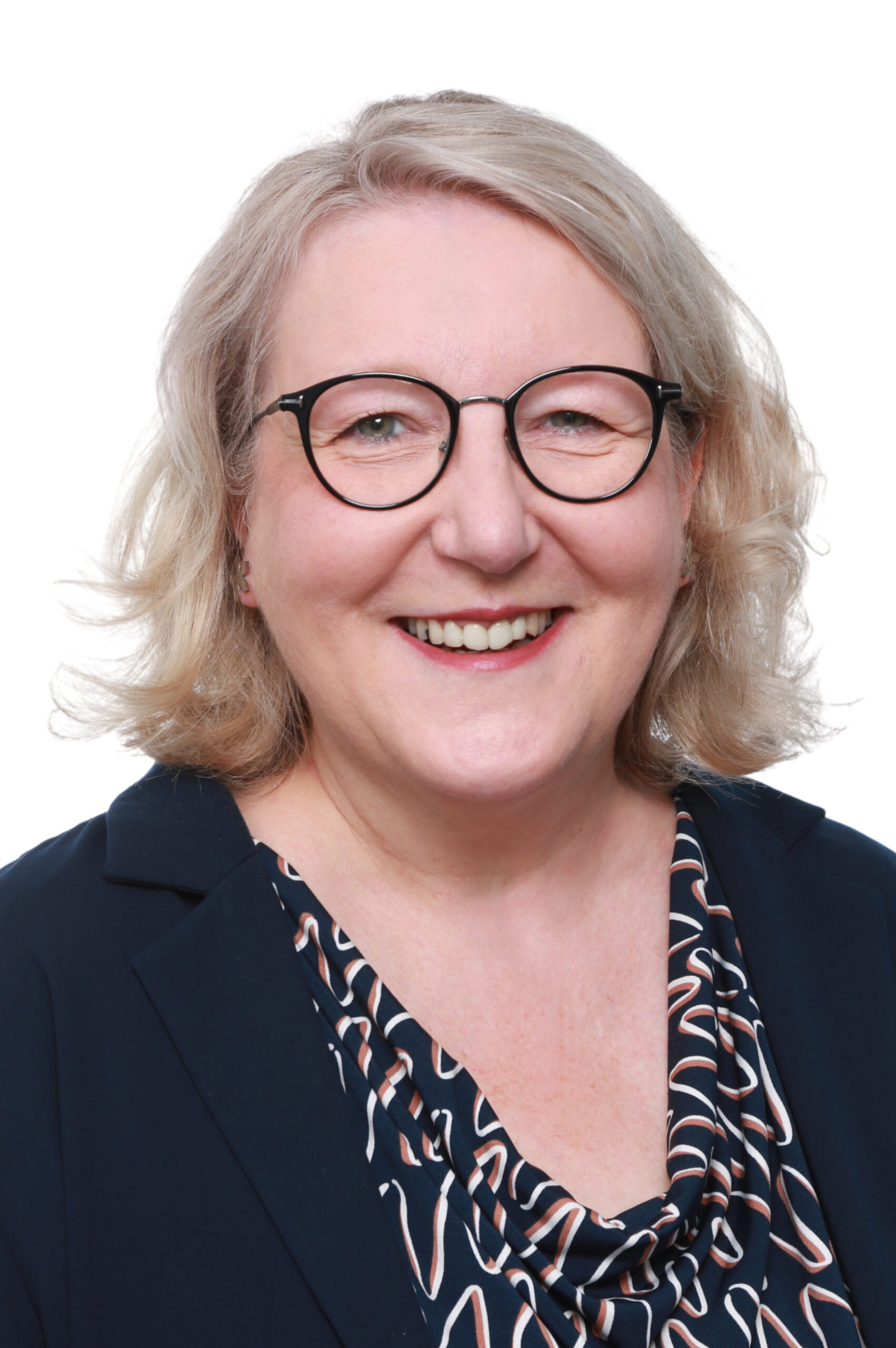 Porträtaufnahme von Kandidatin Bohnsack, lächelnde Frau mit Brille im Blazer.