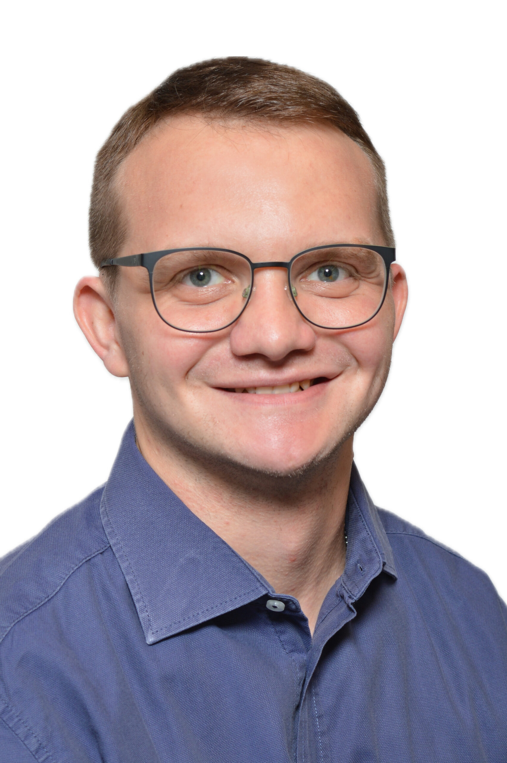 Porträtaufnahme von Kandidat Weiß mit Brille und blauem Hemd, freundlich lächelnd vor weißem Hintergrund.